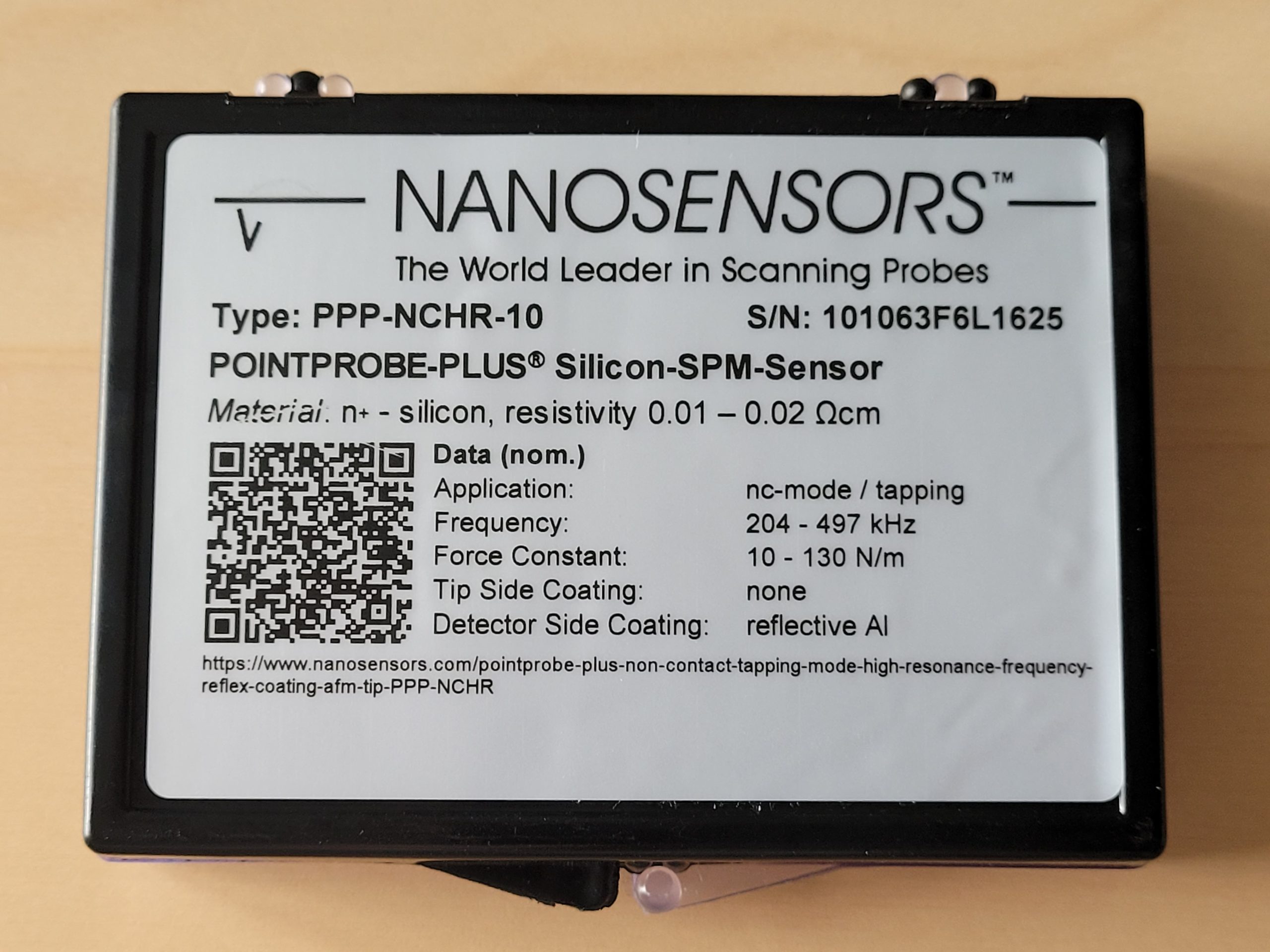 Updated packaging label for a NANOSENSORS AFM probe featuring a QR code linking to product specifications and technical information.