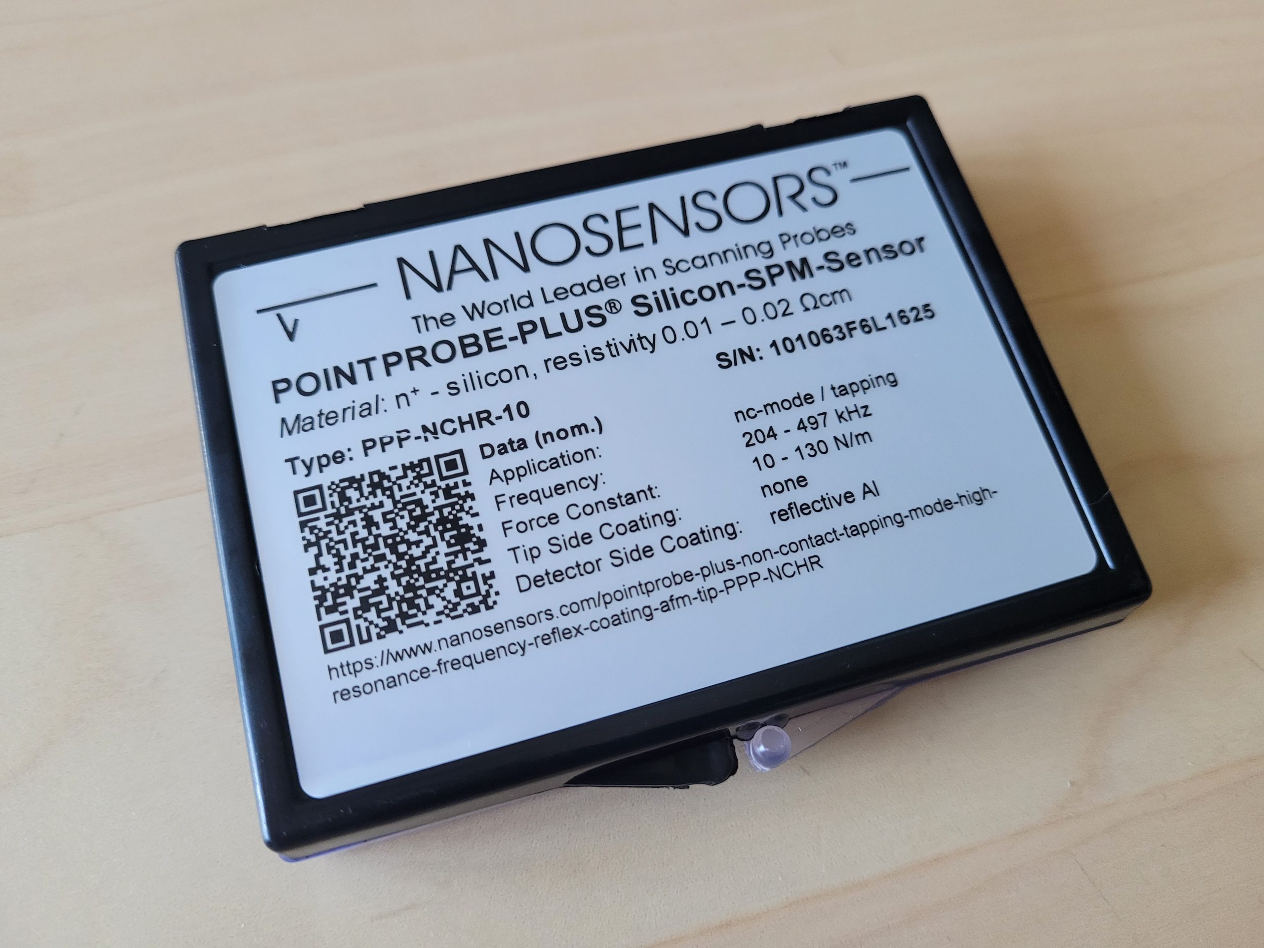Updated packaging label for a NANOSENSORS AFM probe featuring a QR code linking to product specifications and technical information.
